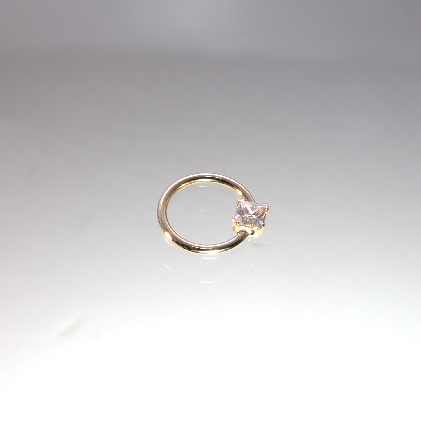Gold ring, piercing, set with princess cut stone